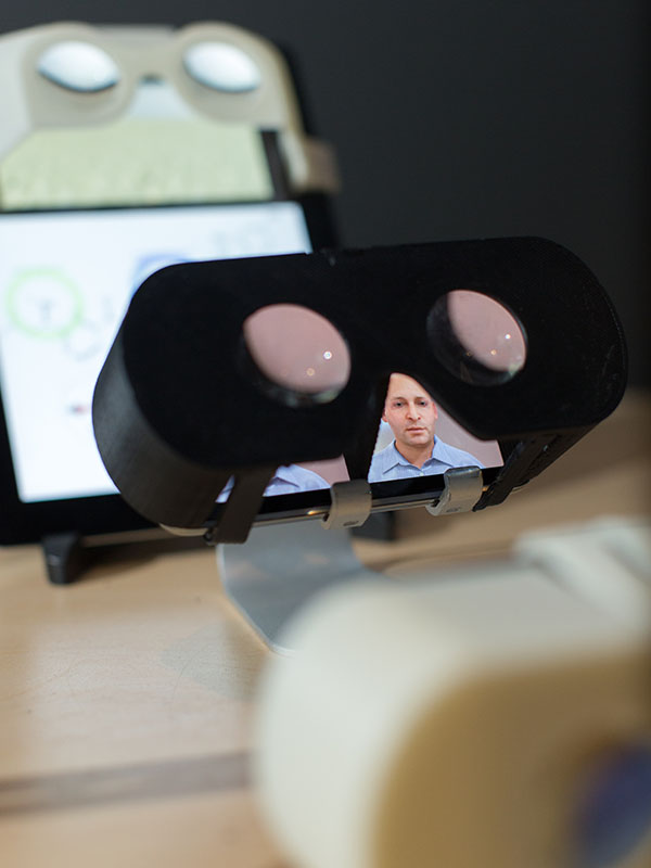 A set of glasses mounted on top of a phone and tablet