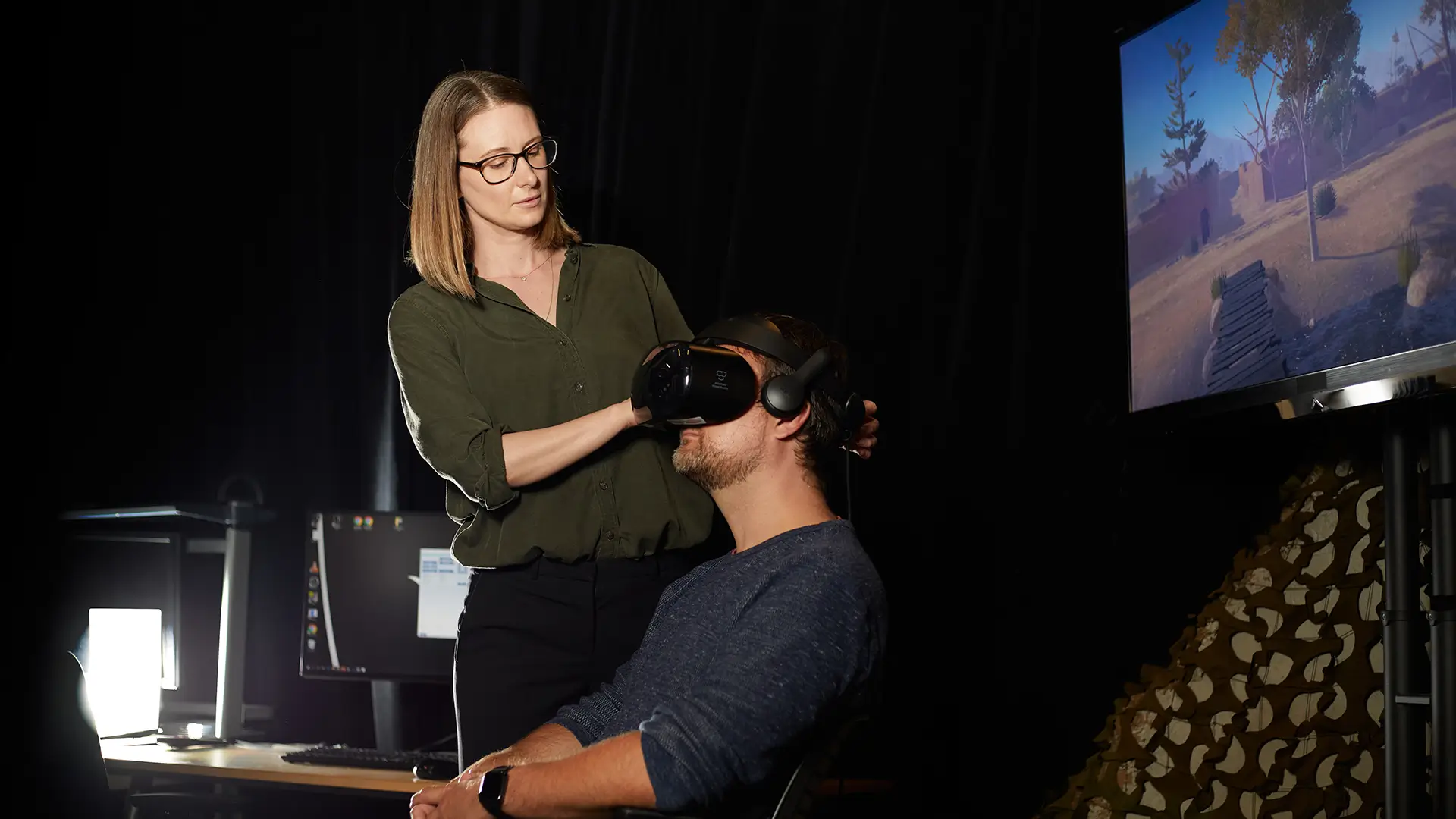Photo of Sharon Mogzai helping a person wear VR headset
