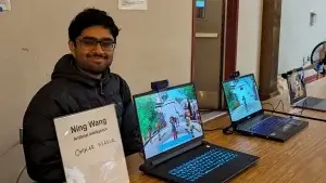 Photo of Omkar Masur demonstrating AI Behind Virtual Humans interface on a laptop